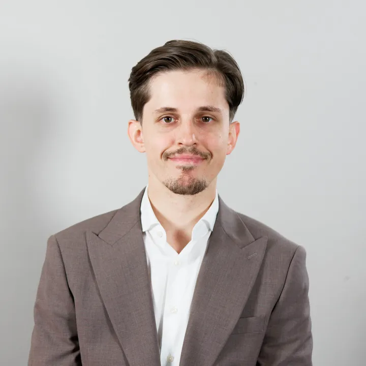 Roman, founder of RK Local Leads, in a gray blazer and white shirt